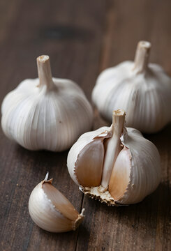 Whole garlic bulbs with loose papery skins rustic kitchen scene