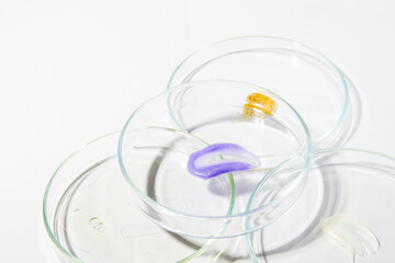 Multiple Petri dishes with liquid smears on light background