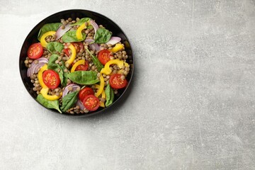 Tasty salad with lentils and vegetables on grey table, top view. Space for text