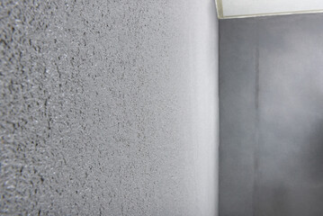 Applying gray concrete pebble plaster kornik on the wall.
