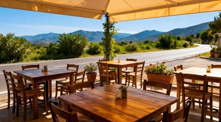 Empty outdoor roadside restaurant tables and chairs with scenic view of green mountains