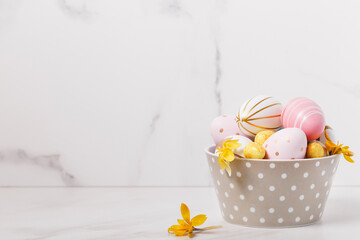 Easter eggs in pastel tones, polka dot bowl, yellow flowers, spring holiday decoration, panoramic banner with copy space, festive Easter background, seasonal greeting card, lifestyle concept