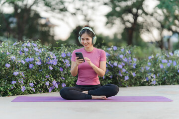 Harmony in the Park: A woman, radiating serenity, enjoys her music outdoors, blending technology with tranquility. Her peaceful practice takes place in a park.