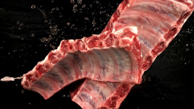 Raw ribs rise and fall on a black background. Filmed on a high-speed camera at 1000 fps. High quality FullHD footage