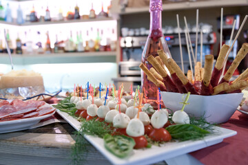 inviting finger foods arranged on a bar with salame, mozzarella, Sala and tomatoes ready for aperitif