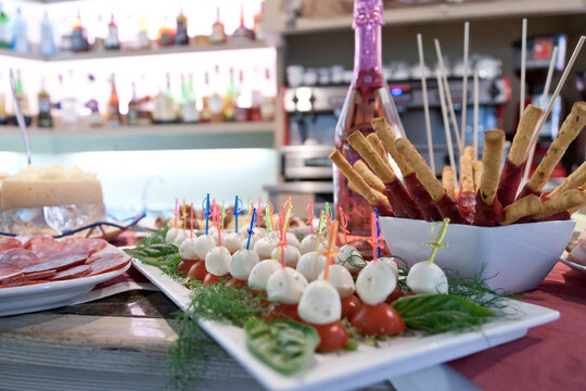 inviting finger foods arranged on a bar with salame, mozzarella, Sala and tomatoes ready for aperitif