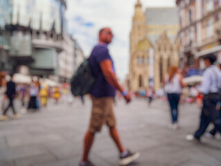 Crowd of anonymous people walking on busy city street	
