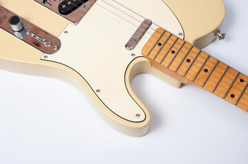 Six-string electric guitar, with a cream-colored wooden body and chrome-plated fittings.