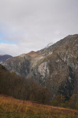 Filter Captures Limestone Peaks Overlooking La Hermida Valley - Soft-focused photograph features a valley in La Hermida, Cantabria, Spain, with lush greenery, red vegetation, and blue sky with clouds.
