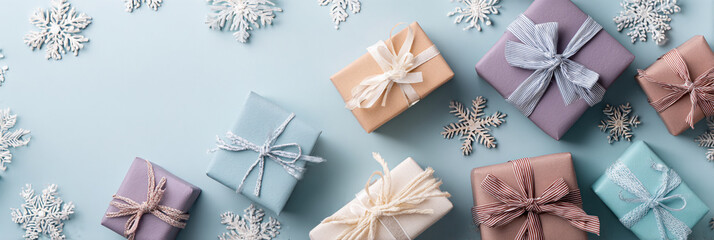 Pastel presents and snowflakes on a light blue background flat lay view