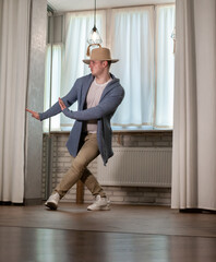 Young guy dancer in motion in a pose. A man performs a modern dance in casual clothes.