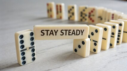 Dominoes falling in a curved line with Stay Steady message