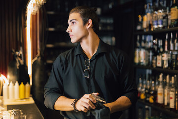 Bartender polishes a glass while standing at the bar