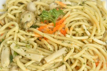 spicy stir fried spaghetti with scallop in garlic butter sauce topping shrimp egg on plate 