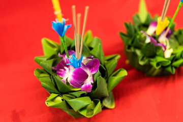 Artificial krathong made from banana leaf for Loy Krathong festival on a red background.