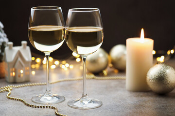Glasses of white wine and Christmas decor on gray table