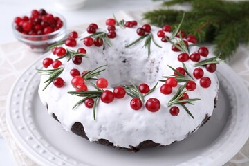 Tasty Christmas cake with cranberries and rosemary on table, closeup
