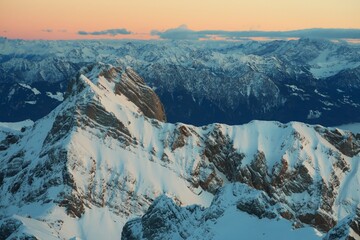 Sonnenuntergang &uuml;ber verschneiten Berggipfeln