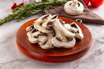Raw champignon slices on the board