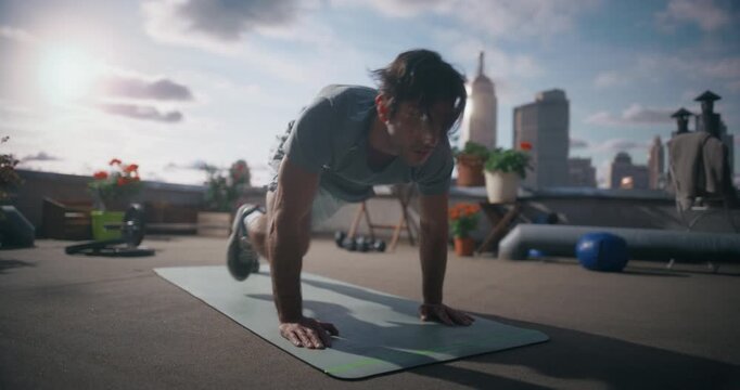 Young Man Performs Mountain Climber Exercise on a Rooftop Mat, Using Bodyweight Training to Build Cardio Fitness, Core Strength, Full Body Outdoor Workout Session in the City.