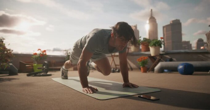 Young Man Performs Fast Mountain Climbers and Steady Pushups on a Rooftop, Using a Phone Timer to Guide a Bodyweight Workout on Strength, Cardio Fitness, and Home Exercise for Everyday Health.