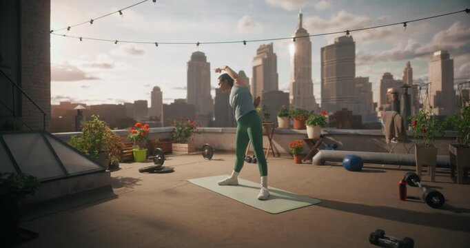 Young Woman Practices Rooftop Fitness Routine, Moving Yoga Stretches and Cardio Exercise to Support Everyday Health, Flexibility, Strength Training in a Outdoor Workout with City View