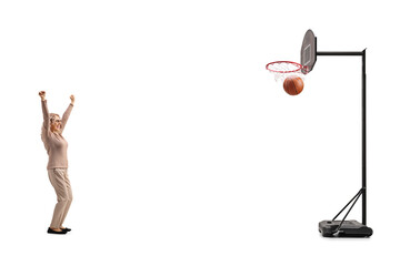 Middle aged woman scoring with a basketball and cheering