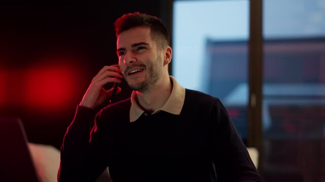 A person talking on the phone with a positive, nice tone in a modern office or studio setting. Light, upbeat mood, friendly discussion, and a productive work atmosphere.