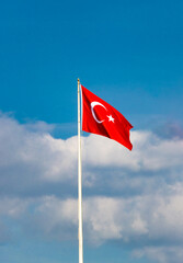 Turkish national flag waving against partly cloudy sky—captured in symbolic composition highlighting cultural identity, open air atmosphere, and patriotic presence.