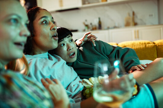 Young adult friends scared while watching movie at home
