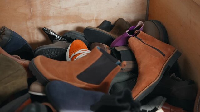various discarded shoes gathered in container for recycling facility