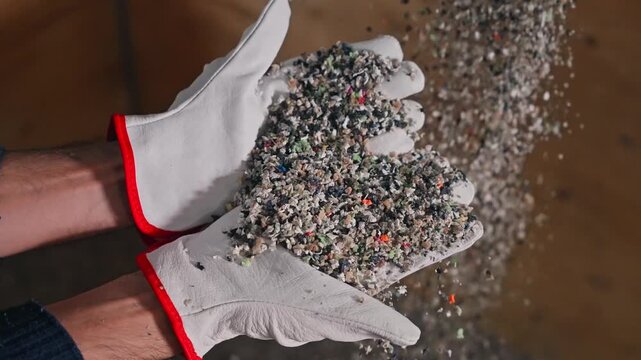 fine recycled rubber granules flowing through protective gloves