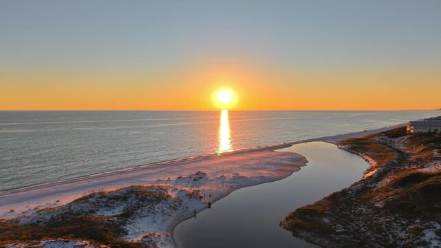 Drone orbit in romantic sunset glowing at Draper Lake endpoint meeting Gulf of Mexico, Old Florida Beach, Florida, USA