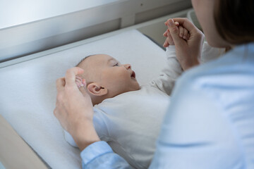 Obraz premium Mother gently holding baby's hands showing closeness and care