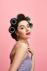 Naklejka premium Charming young woman with curlers embracing beauty in a playful setting