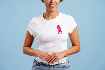 Woman wearing pink ribbon for breast cancer awareness, supporting health campaign