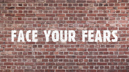 Inscription &laquo;Face your fears&raquo; on old brickwork