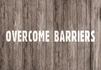 The inscription &laquo;overcome barriers&raquo; on old wooden boards