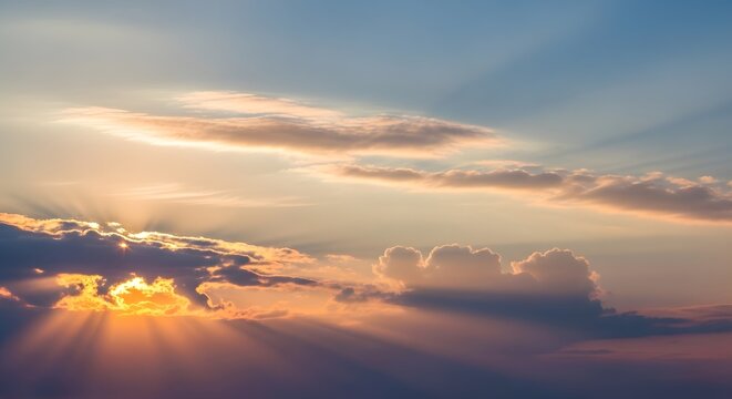 Golden sunbeams pierce through wispy clouds at sunset