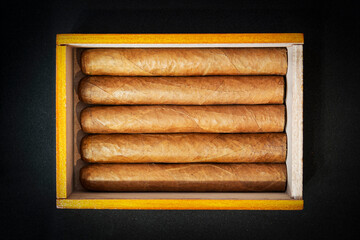 Box of Cuban Cigars on black table in the dark. Expensive cigars as a gift.