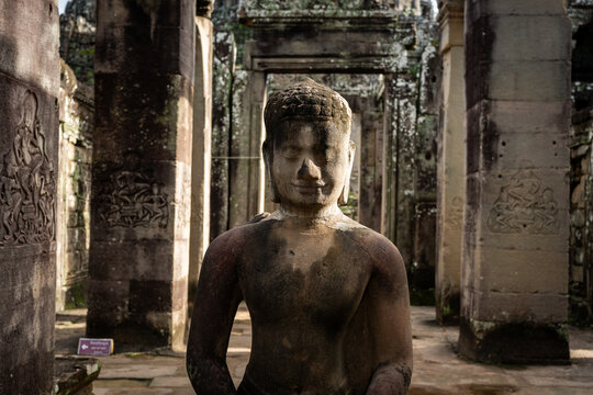 Ancient Buddha statue in the temple of Angkor Wat, Cambodia, with detailed carvings