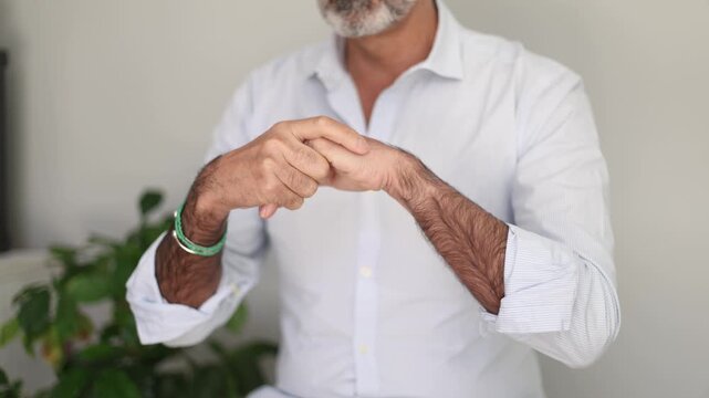 Mature man cracking his knuckles and stretching his fingers