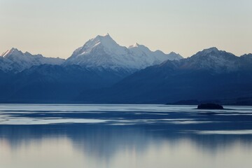 Lake Pukaki, NZ - May 24, 2025 (Twilight): Panoramic view, snow-capped Aoraki-Mount Cook massif, glowing, twilight colors. Majestic mountain is perfectly reflected in the still water of Lake Pukaki