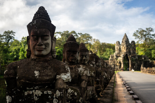 Ancient stone statues guarding the entrance to Angkor Thom temple in Cambodia