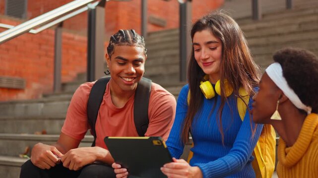 Three diverse university students studying with tablet