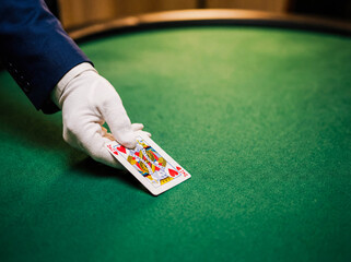 Dealer hand dealing cards green felt table copy space casino blackjack poker gambling game professional croupier service luxury atmosphere entertainment betting concept close up background banner