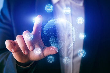 Professional touching digital globe with floating icons representing global connections and technology in a modern business setting
