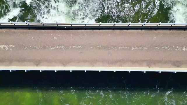 Flying up over a bridge while a river flows under it