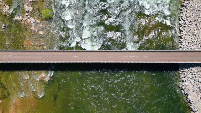 Flying up over a bridge while a river flows under it