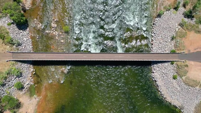 Flying up over a bridge while a river flows under it